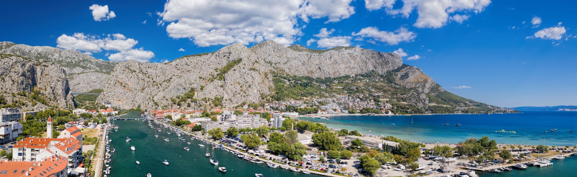 Amazing panorama of Omis wiith boats on Cetina river and beaches along the coast in Croatia
